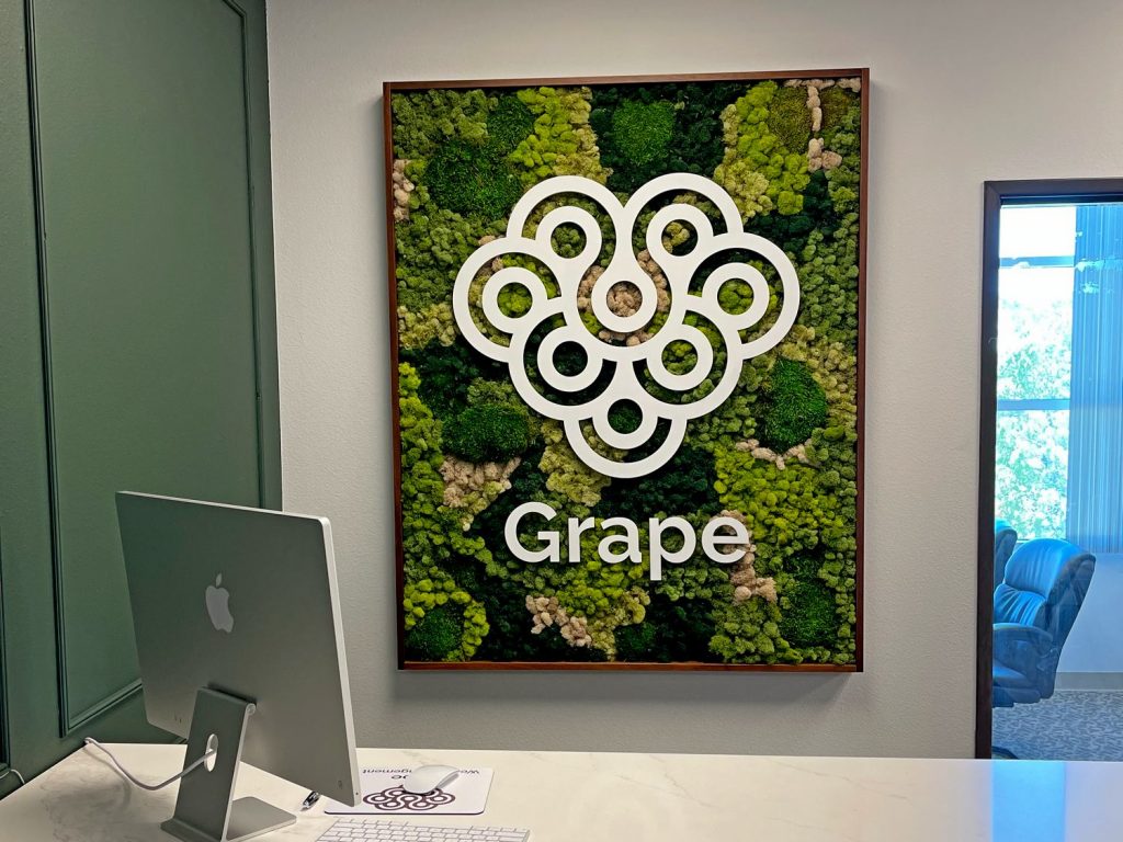 Wood framed moss panel with white acrylic logo for office reception