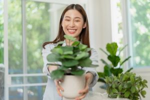 Lady giving mom a housepalnt for mothers day - Top Houseplants to Gift Mom Instead of Flowers