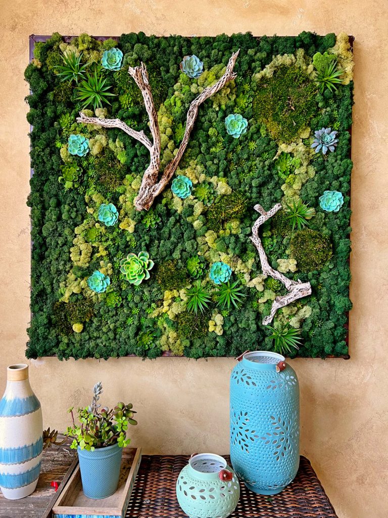 Preserved moss artwork with drift wood and faux plants