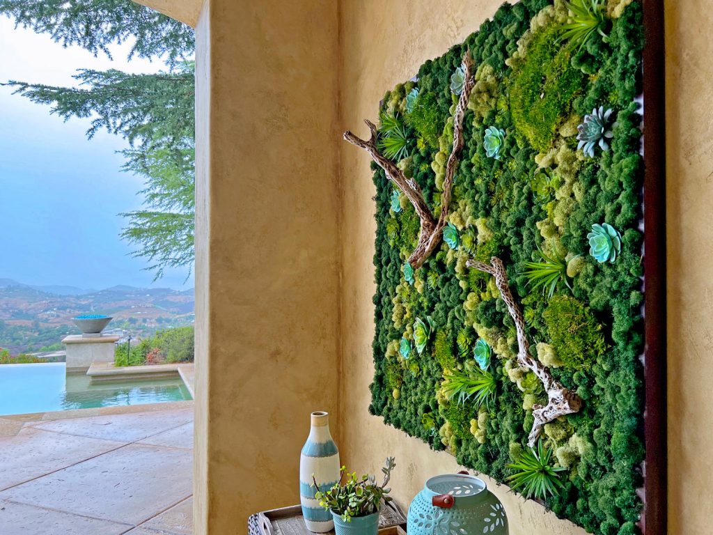 Moss panel for backyard patio with faux plants and natural materials