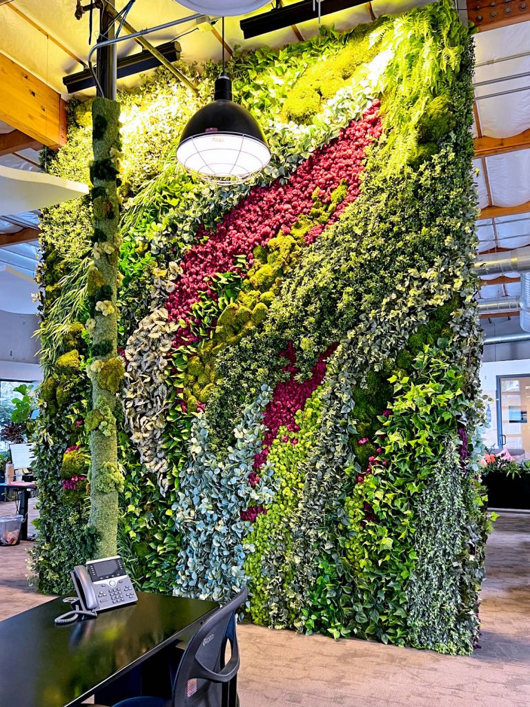 Large wall wrapped with faux plants for contemporary office